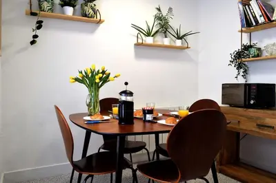 a dining room table and chairs with flowers on it at Breathtaking High Street Townhouse With Stunning Sea Views at 'The Old Fishermans Townhouse' in Falmouth