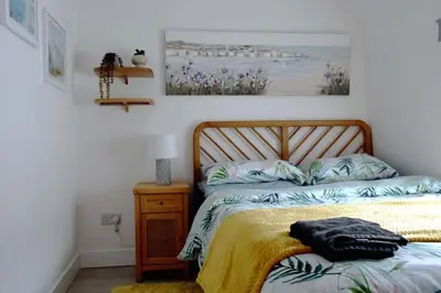 a bedroom with a bed and a picture on the wall at Breathtaking High Street Townhouse With Stunning Sea Views at 'The Old Fishermans Townhouse' in Falmouth