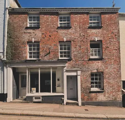 an old brick building with windows and a door at Breathtaking High Street Townhouse With Stunning Sea Views at 'The Old Fishermans Townhouse' in Falmouth