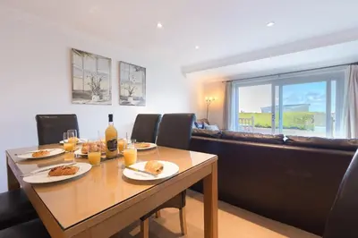 a dining room with a table with plates of food at Gennaker in Carbis Bay