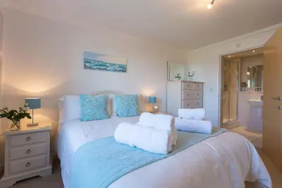 a bedroom with a large bed with two pillows at Gennaker in Carbis Bay