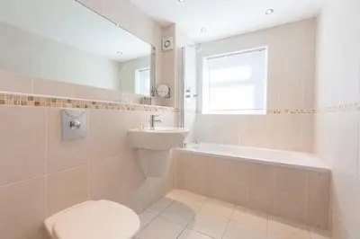 a bathroom with a toilet and a sink and a tub at Gennaker in Carbis Bay