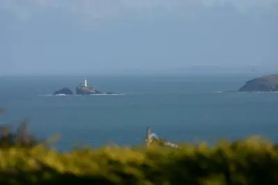 a large body of water with a lighthouse in the distance at Gennaker in Carbis Bay