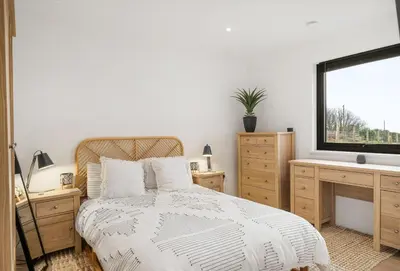 a bedroom with a bed and a television on a desk at Poppyfields in Germoe