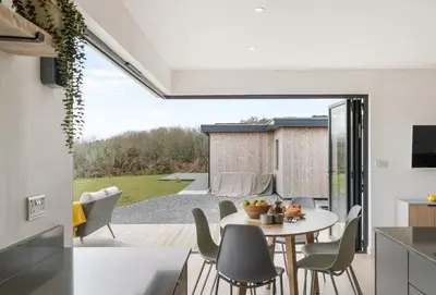 a kitchen and dining room with a table and chairs at Poppyfields in Germoe