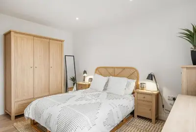 a bedroom with a bed and a wooden cabinet at Poppyfields in Germoe