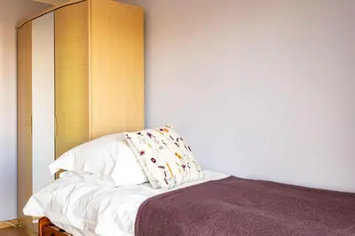 a bed with a wooden headboard and a pillow on it at Blue Ridge in Wadebridge