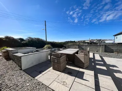 a patio with a picnic table and wicker baskets at Blue Ridge in Wadebridge