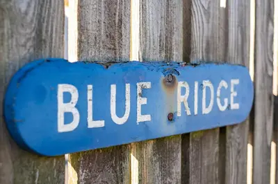 a blue sign on a fence with the word blue ridge at Blue Ridge in Wadebridge