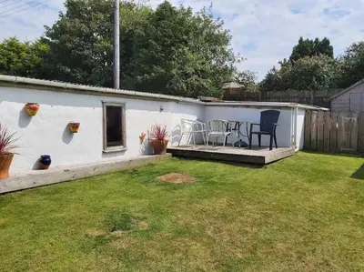 a patio with two chairs and a table in a yard at Poppy's Place Annex in Camelford North Cornwall in Camelford