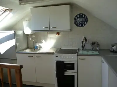 a kitchen with white cabinets and a stove and a sink at Poppy's Place Annex in Camelford North Cornwall in Camelford