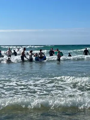 a group of people in the water at the beach at Atlantic Lodge in Newquay
