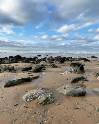 a beach with rocks on the sand and the water at Atlantic Lodge in Newquay