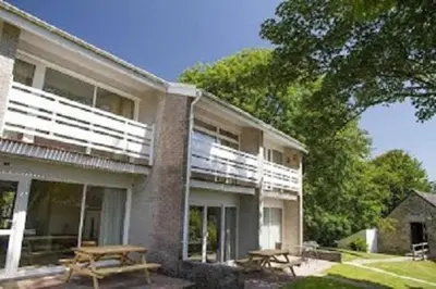 a building with two picnic tables in front of it at Atlantic Lodge in Newquay