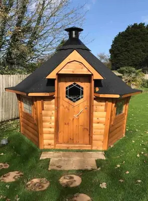 a small wooden dog house with a black roof at Romantic Treehouse with Hot Tub & BBQ Lodge in Praze an Beeble