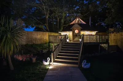 a small gazebo with stairs and a gazebo with at Romantic Treehouse with Hot Tub & BBQ Lodge in Praze an Beeble