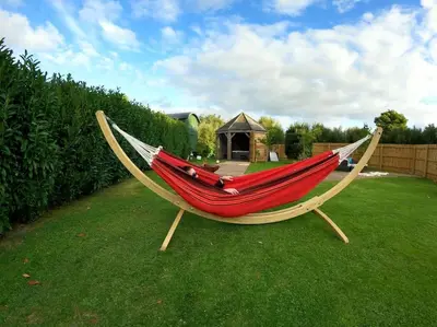 a hammock in a yard with a gazebo at Romantic Retreat - Luxury Shepherds Hut + Hot Tub! in Camborne