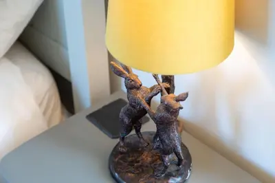 a lamp with two deer figurines on a table at Millook View Farmhouse in Bude
