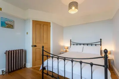 a bedroom with a bed and a radiator at Millook View Farmhouse in Bude