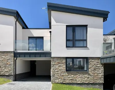 a white house with black windows and a driveway at Tolcarne - Perranporth Cornwall in Perranporth
