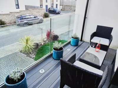 a balcony with a table and chairs and plants at Tolcarne - Perranporth Cornwall in Perranporth