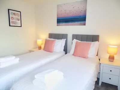 two twin beds in a room with two lamps at Tolcarne - Perranporth Cornwall in Perranporth