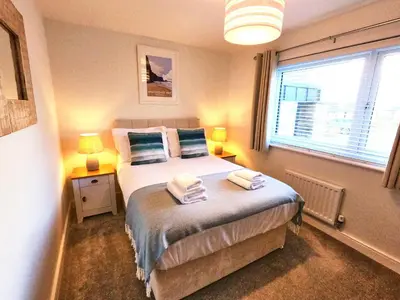 a bedroom with a bed with towels on it at Tolcarne - Perranporth Cornwall in Perranporth