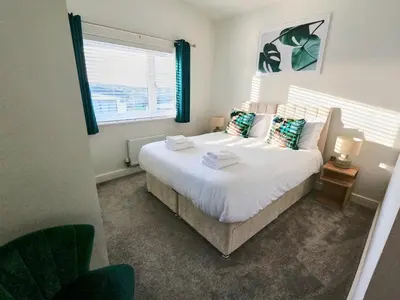 a bedroom with a large white bed and a window at Tolcarne - Perranporth Cornwall in Perranporth