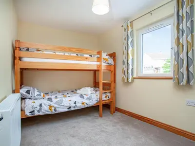 a bedroom with two bunk beds and a window at Trelawney Cottage in Charlestown