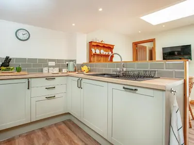 a kitchen with white cabinets and a sink at Trelawney Cottage in Charlestown