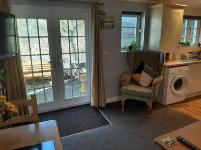 a living room with a chair and a washing machine at Cozy Courtyard Apt Explore & Relax Free Parking in Bodmin
