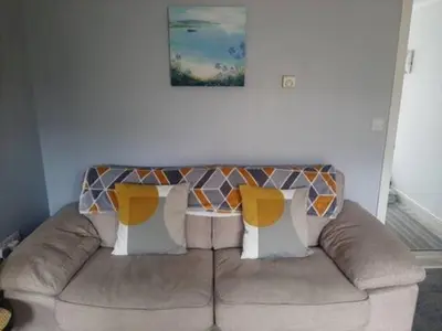 a couch with two pillows on it in a living room at Cozy Courtyard Apt Explore & Relax Free Parking in Bodmin