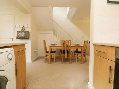 a kitchen and dining room with a table and chairs at Mulberry Cottage in Falmouth