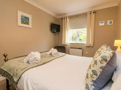 a bedroom with a bed with towels on it at Mulberry Cottage in Falmouth