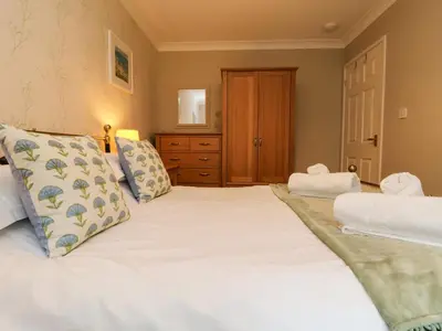 a bedroom with a large white bed with two pillows at Mulberry Cottage in Falmouth