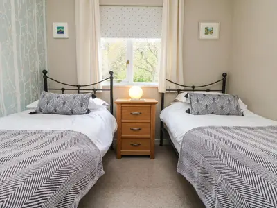 a bedroom with two beds and a window at Mulberry Cottage in Falmouth
