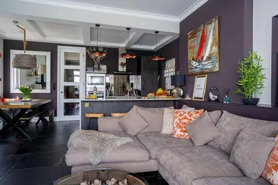 a living room with a couch and a kitchen at Marners Rock No 3 in Fowey