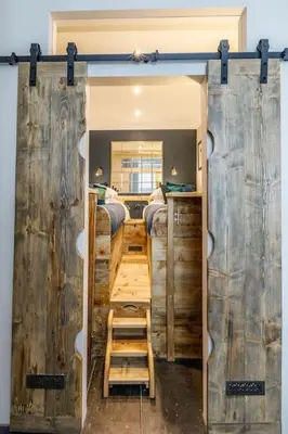 a bedroom with a door open to a room with bunk beds at Marners Rock No 3 in Fowey