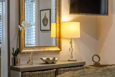 a mirror and a lamp on a table in a room at Marners Rock No 3 in Fowey