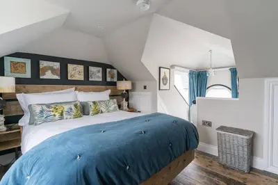 a bedroom with a large bed with blue sheets at Marners Rock No 2 in Fowey