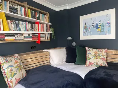 a bedroom with a bed and a book shelf with books at Marners Rock No 2 in Fowey