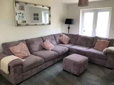 a brown couch in a living room with a mirror at 4 bedroom luxurious detached home in Liskeard
