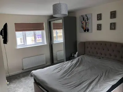 a bedroom with a large bed and a mirror at 4 bedroom luxurious detached home in Liskeard