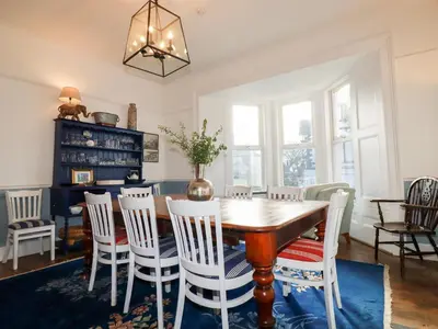 a dining room with a wooden table and chairs at Melvill House in Falmouth