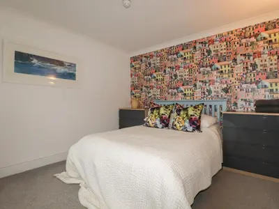 a bedroom with a bed with a wall covered in photographs at Melvill Lower Deck in Falmouth