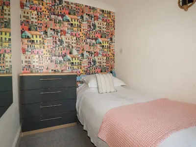 a bedroom with a bed and a wall with buildings at Melvill Lower Deck in Falmouth