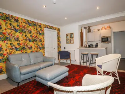a living room with a couch and a kitchen at Melvill Lower Deck in Falmouth