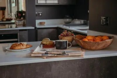 a kitchen counter with bowls of oranges and a cup of coffee at Marners Rock No 1 in Fowey