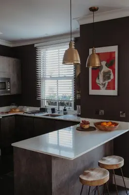 a kitchen with a large white island with two stools at Marners Rock No 1 in Fowey