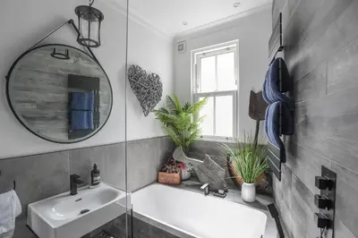 a bathroom with a tub and a sink and a mirror at Marners Rock No 1 in Fowey
